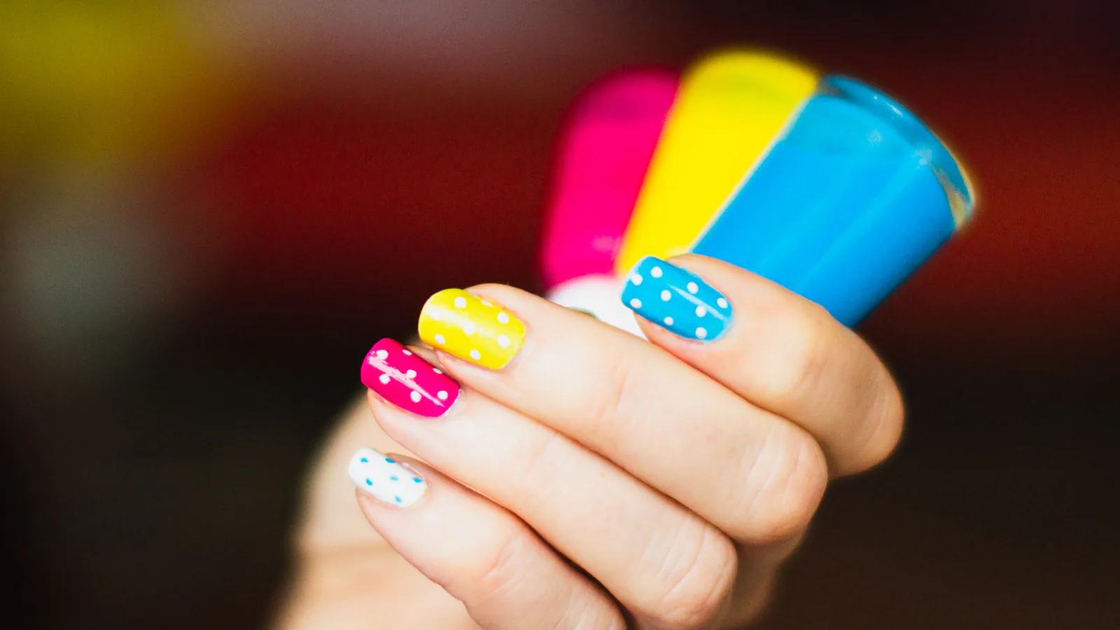 Press-on nail art with thin lines and small dots layered over a glossy tip